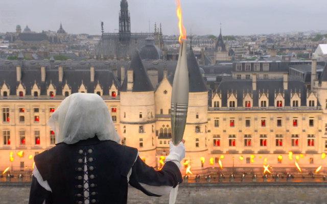 Paris roars back to life as Olympics 2024 open finally Mysterious figure holding the torch
